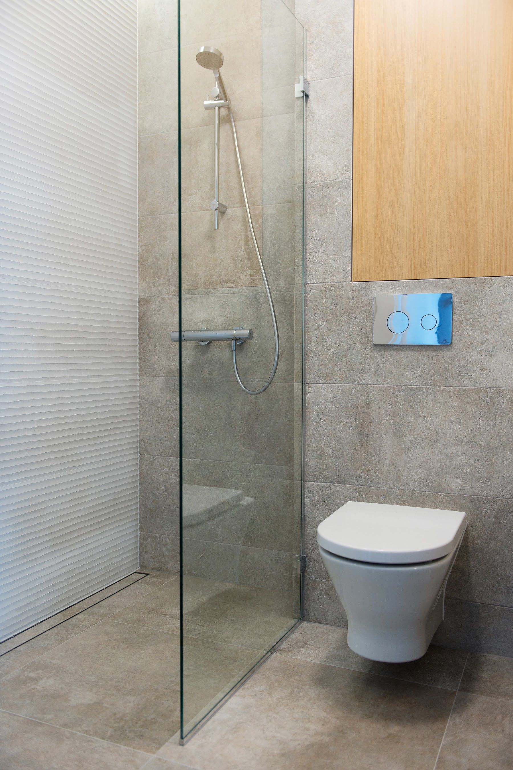 Prysznic walk in z ukrytymi wnękami na kosmetyki.