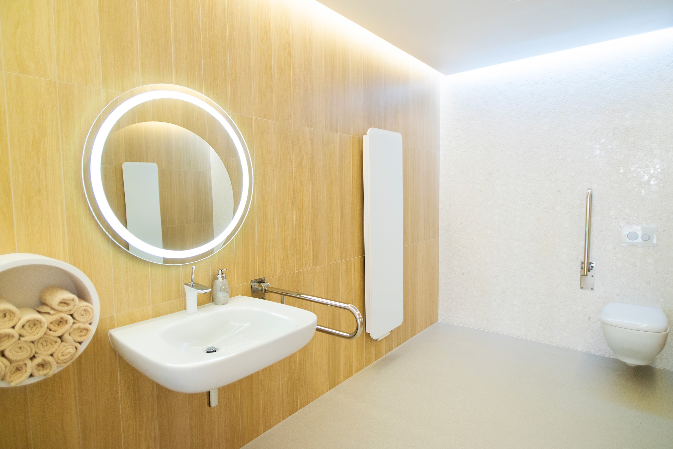 Przestronna łazienka na parterze, z marmurową mozaiką na ścianie.